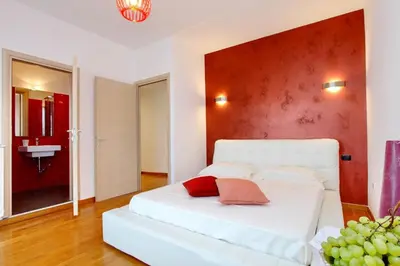 a white bed in a room with a red wall at Monteverde Nuovo Penthouse in Rome