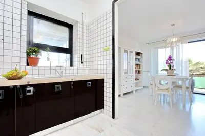 a kitchen with a sink and a dining room with a table at Monteverde Nuovo Penthouse in Rome