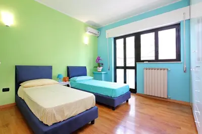 a bedroom with two beds and blue walls at Monteverde Nuovo Penthouse in Rome