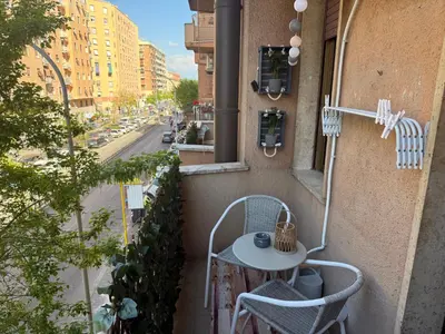 a balcony with a table and chairs and a street at ALCAVE holiday home in Rome