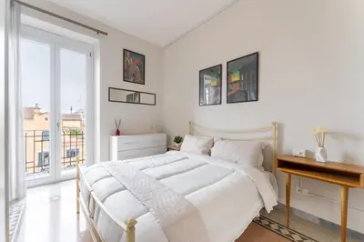 a white bedroom with a bed and a desk at La Galleria, Rooftop Flat Nearby Villa Borghese in Rome