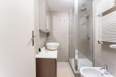 a white bathroom with a sink and a shower at La Galleria, Rooftop Flat Nearby Villa Borghese in Rome