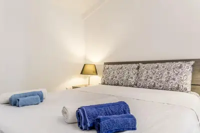 a bedroom with a white bed with blue towels on it at Ninkasi Bed and Beer Loft in Rome