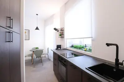 a kitchen with a counter and a sink and a table at LRV Apartment Roma Metro B Conca d'Oro in Rome