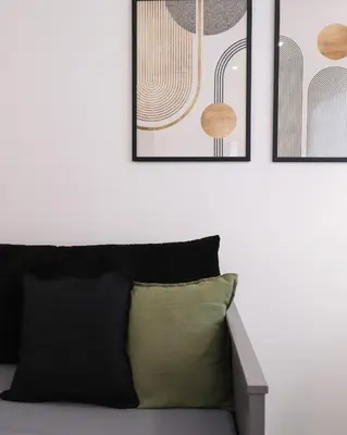 a living room with a couch and three framed pictures at LRV Apartment Roma Metro B Conca d'Oro in Rome