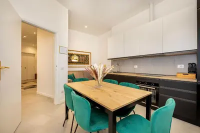 a kitchen with a wooden table and green chairs at Roma Borghese - casa vacanze in Rome