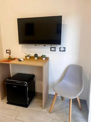 a desk with a chair and a television on a wall at Costabella Guest House in Rome
