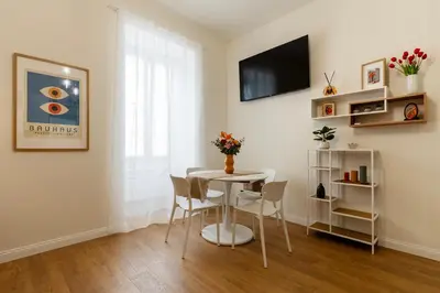 a dining room with a white table and chairs at PictaDomus-Albus, Metro Furio Camillo in Rome