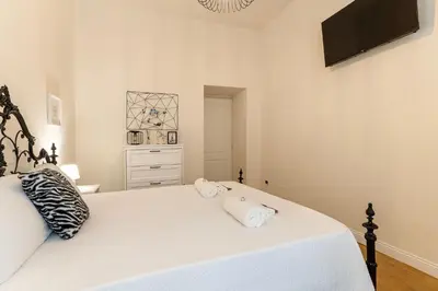 a bedroom with a white bed with two pillows on it at PictaDomus-Albus, Metro Furio Camillo in Rome