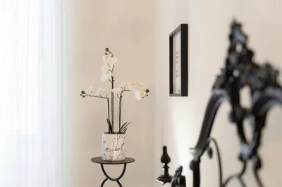 a vase with white flowers sitting on a table at PictaDomus-Albus, Metro Furio Camillo in Rome