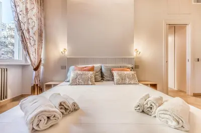 a bedroom with a large white bed with towels on it at Gianicolo Suites in Rome