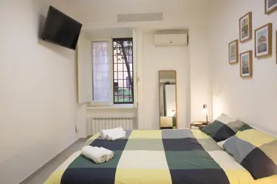 a bedroom with two beds and a tv on the wall at Sunny's Suite - 8min from Colosseum in Rome