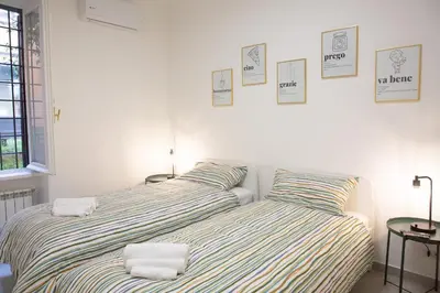 two beds sitting next to each other in a bedroom at Sunny's Suite - 8min from Colosseum in Rome