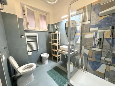 a bathroom with a toilet and a glass shower at Sunny's Suite - 8min from Colosseum in Rome