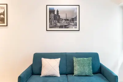 a blue couch in a living room with two pillows at Amazing Tacito in Rome