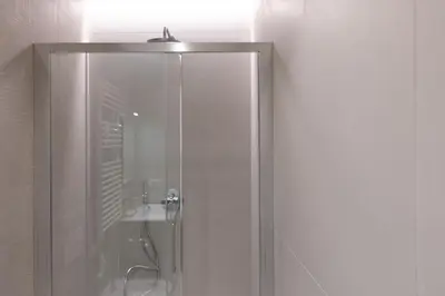 a shower with a glass door in a bathroom at Amazing Tacito in Rome