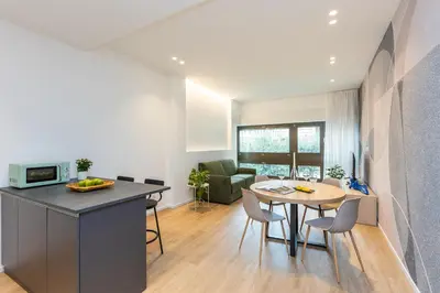 a kitchen and living room with a table and a dining room at Amazing Tacito in Rome