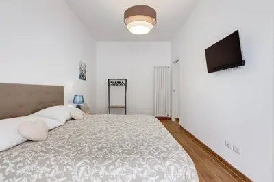 a bedroom with a large bed and a flat screen tv at Apartment Vatican with 2 bathrooms and terrace in Rome