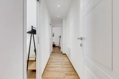a hallway with white walls and a wooden floor at Apartment Vatican with 2 bathrooms and terrace in Rome