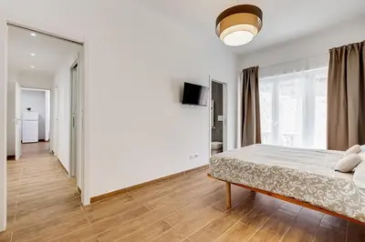 a white bedroom with a bed and a large window at Apartment Vatican with 2 bathrooms and terrace in Rome