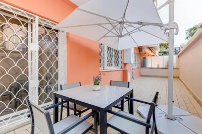 a table and chairs with an umbrella on a patio at Apartment Vatican with 2 bathrooms and terrace in Rome