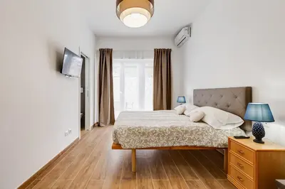 a white bedroom with a bed and a window at Apartment Vatican with 2 bathrooms and terrace in Rome