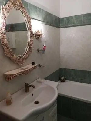 a bathroom with a sink and a mirror and a tub at LIAM condo in Rome