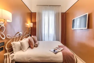 a bedroom with a bed and a television on a wall at Telier Ripetta in Rome