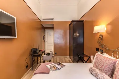 a room with a bed and a table with a desk at Telier Ripetta in Rome