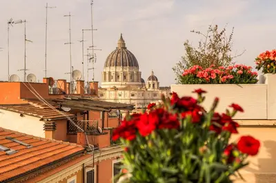 a view of a cathedral with red flowers on roofs at La terrazza di Vanessa in Rome