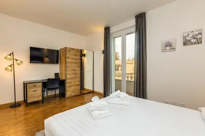 a hotel room with a bed and a desk and a window at La terrazza di Vanessa in Rome