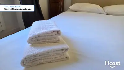 two towels are stacked on top of a bed at Rienzo Charme Apartment in Rome