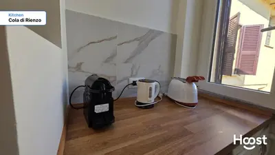 a kitchen with two appliances sitting on a wooden floor at Rienzo Charme Apartment in Rome