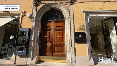 a large wooden door on a building with windows at Rienzo Charme Apartment in Rome