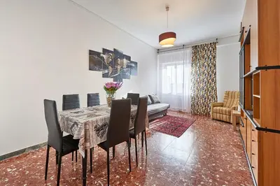 a dining room with a table and chairs and a couch at 15 minuti da San Giovanni - A c, Wifi e Smart Tv in Rome
