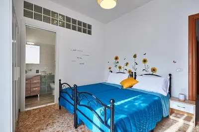 a bedroom with a blue bed and a bathroom at 15 minuti da San Giovanni - A c, Wifi e Smart Tv in Rome