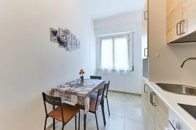 a dining room with a table and chairs in a kitchen at 15 minuti da San Giovanni - A c, Wifi e Smart Tv in Rome