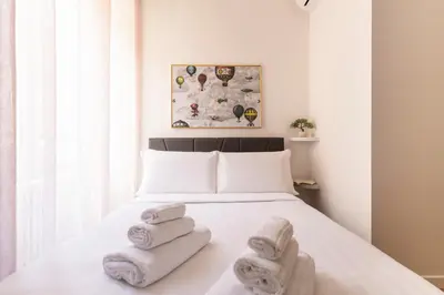a bedroom with a bed with towels on it at Hostly-Puccini Luxury Home-Near Colosseum & Trevi in Rome