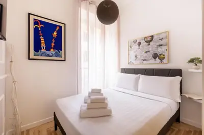 a bedroom with a white bed in a room at Hostly-Puccini Luxury Home-Near Colosseum & Trevi in Rome