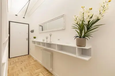 a white room with white shelves and a potted plant at Hostly-Puccini Luxury Home-Near Colosseum & Trevi in Rome