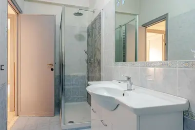 a white bathroom with a sink and a shower at Dolce vita romana in Rome