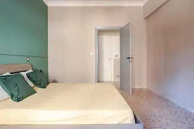 a bedroom with two beds with green and white walls at Dolce vita romana in Rome