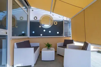 a room with two chairs and a table and a mirror at Attico 4M - Ospedale Gemelli e Vista Panoramica by Hôtea in Rome