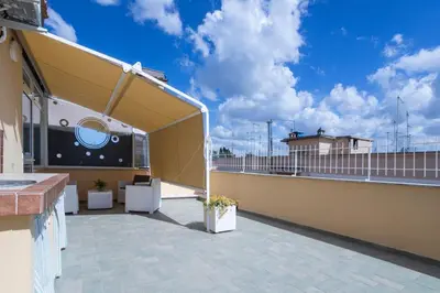 a balcony with awning on a building with a sky at Attico 4M - Ospedale Gemelli e Vista Panoramica by Hôtea in Rome