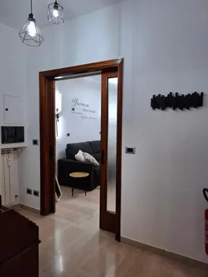 a living room with a mirror and a couch at Rome Lumina - Bilocale luminoso vicino Metro C, 6 fermate dal Colosseo in Rome