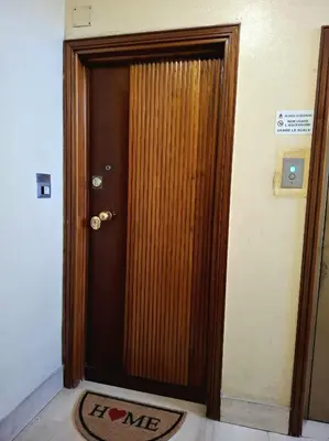 a wooden door in a room with a mat in front of it at Rome Lumina - Bilocale luminoso vicino Metro C, 6 fermate dal Colosseo in Rome