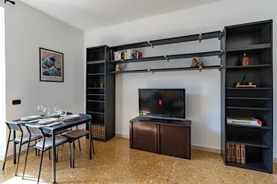 a living room with a table and a television and shelves at Brunetta Cozy Apartment-Metro B in Rome