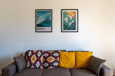 a living room with a couch and three pictures on the wall at Brunetta Cozy Apartment-Metro B in Rome
