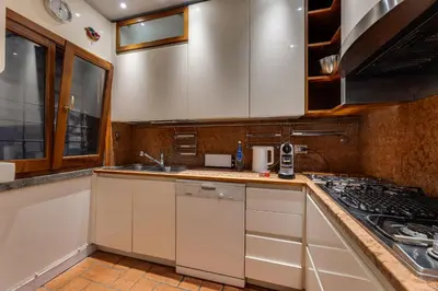 a kitchen with white cabinets and a stove at Fico Giallo - Piazza Navona Apartment in Rome