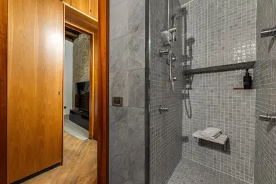 a bathroom with a shower with gray tiles at Fico Giallo - Piazza Navona Apartment in Rome